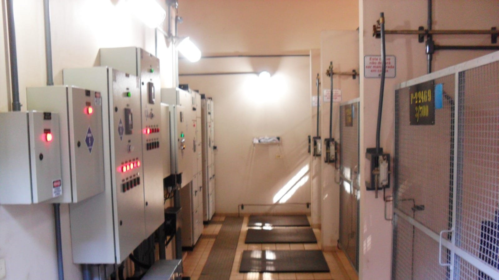 Sala de painéis elétricos industriais com quadros de comando e centro de medição em operação